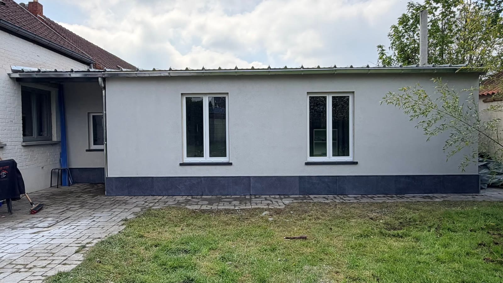 Le même bungalow rénové, façade neuve et toiture métallique