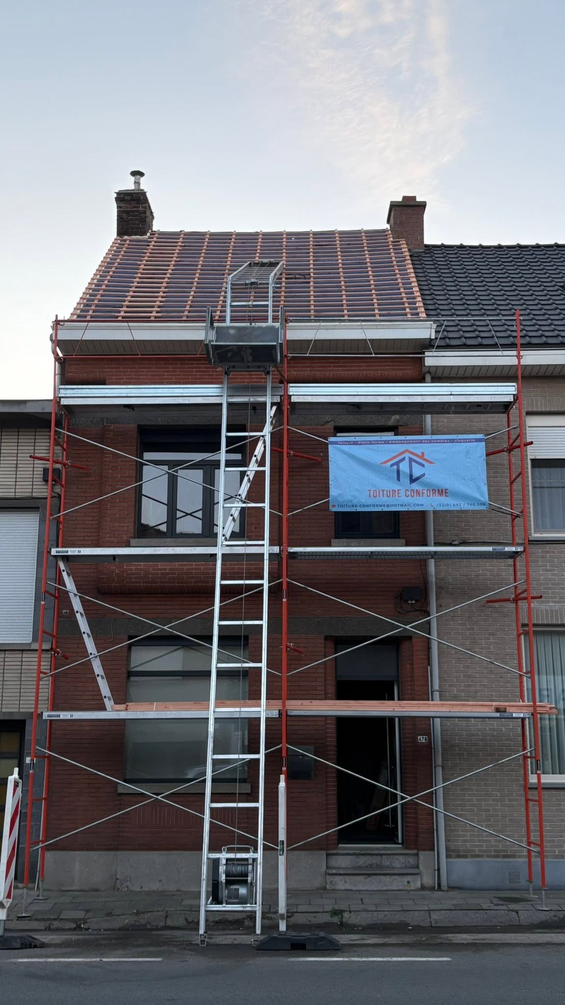 Échafaudage Toiture conforme avec la banderole de l'entreprise sur un chantier à Tournai