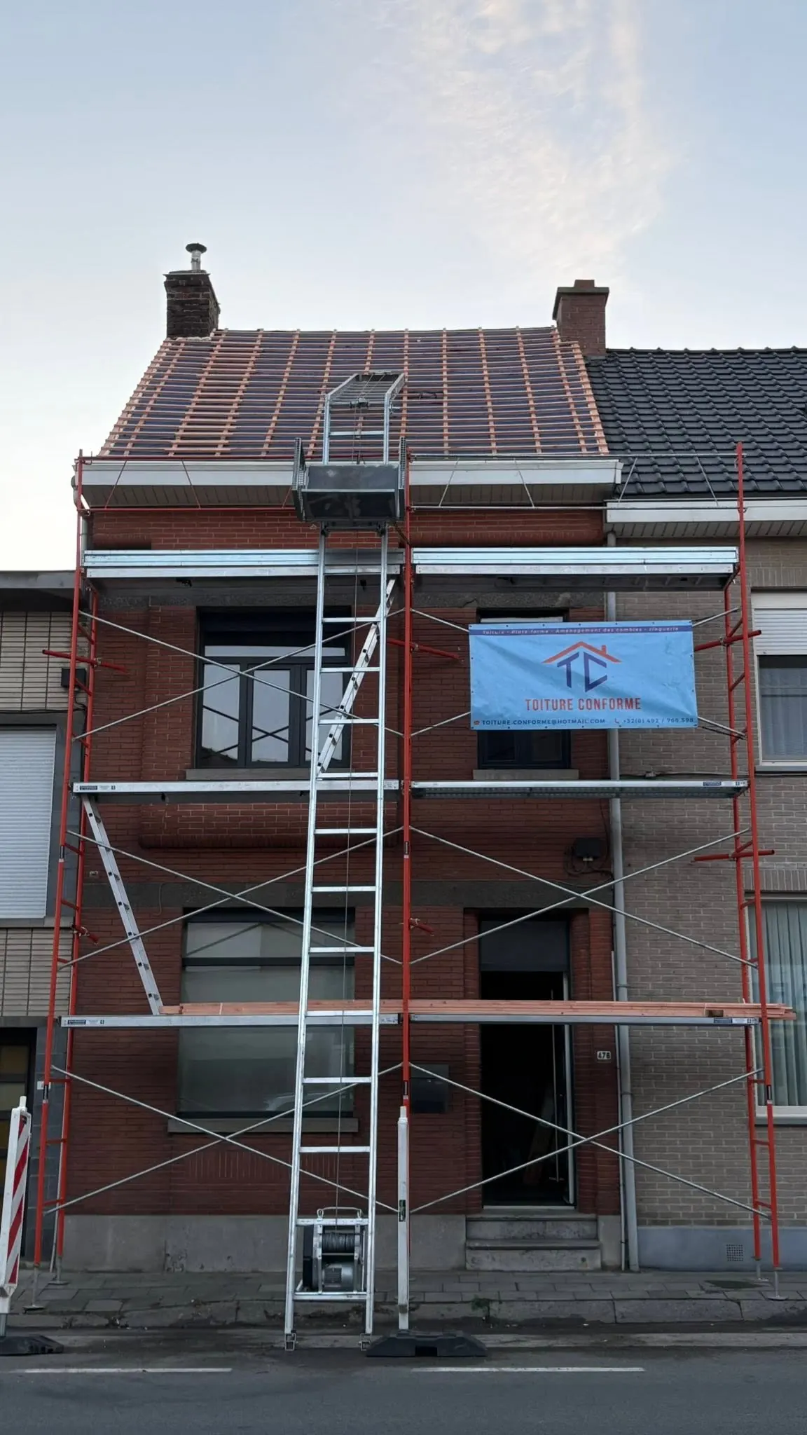 Échafaudage Toiture conforme avec la banderole de l'entreprise sur un chantier à Tournai